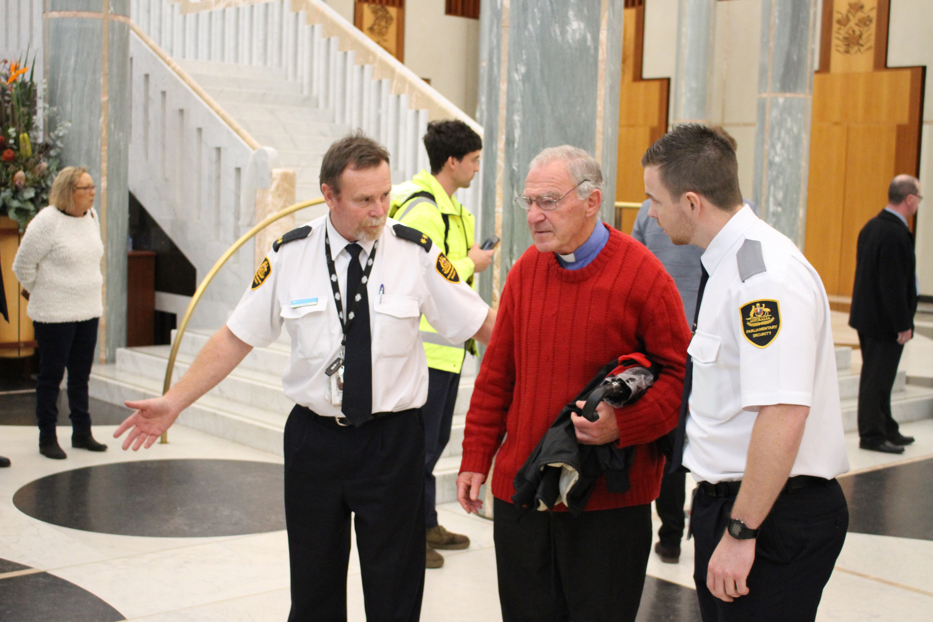 Bishop Pat Power being escorted from Parliament House