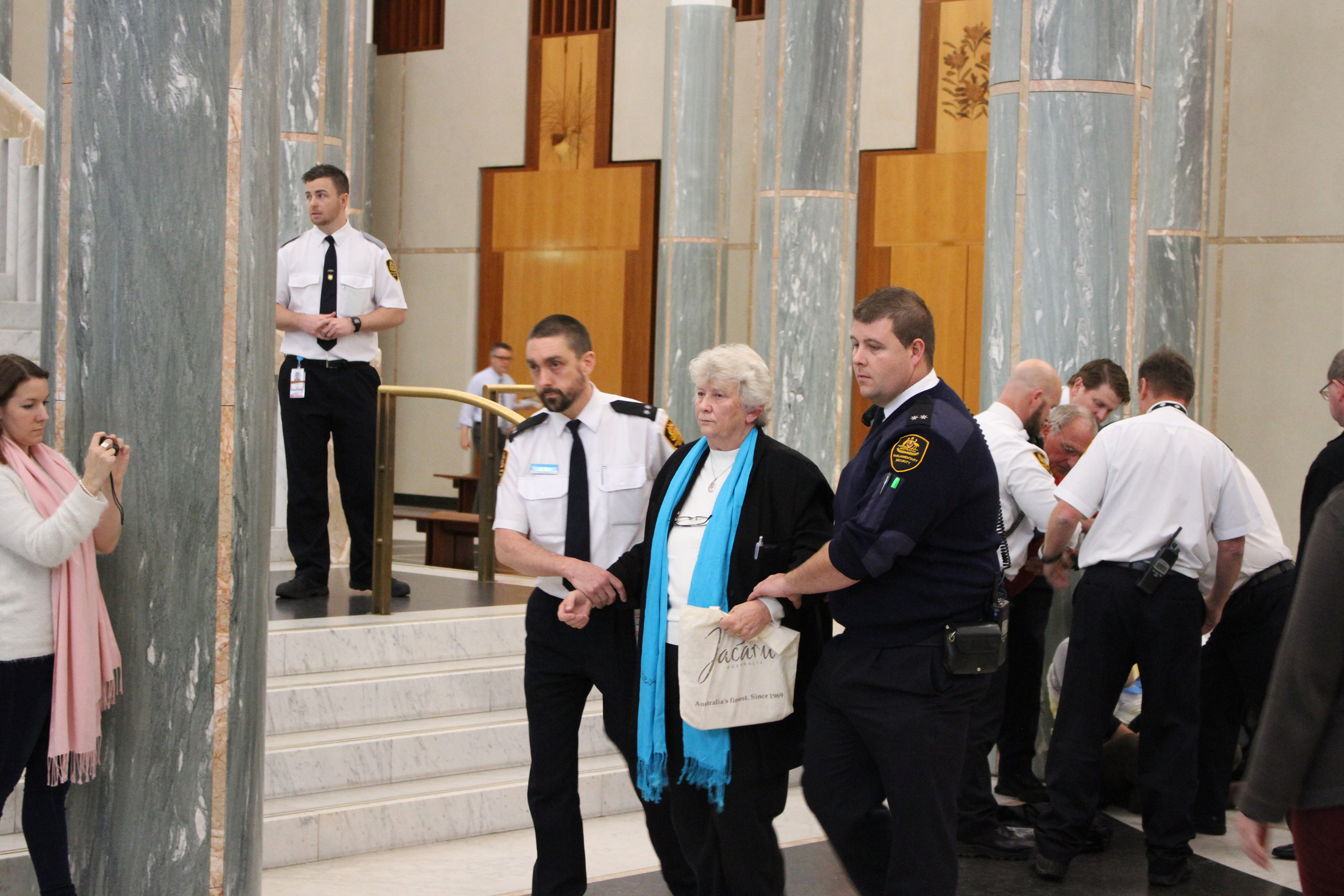 Susan Connelly being escorted from Parliament House